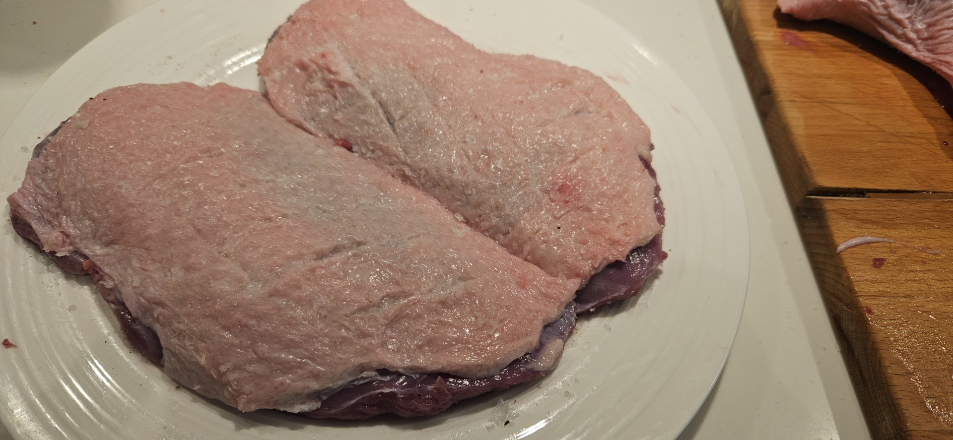 Trim the breasts, score the skin closely without cutting the meat, pat dry, and salt well for crisp skin.