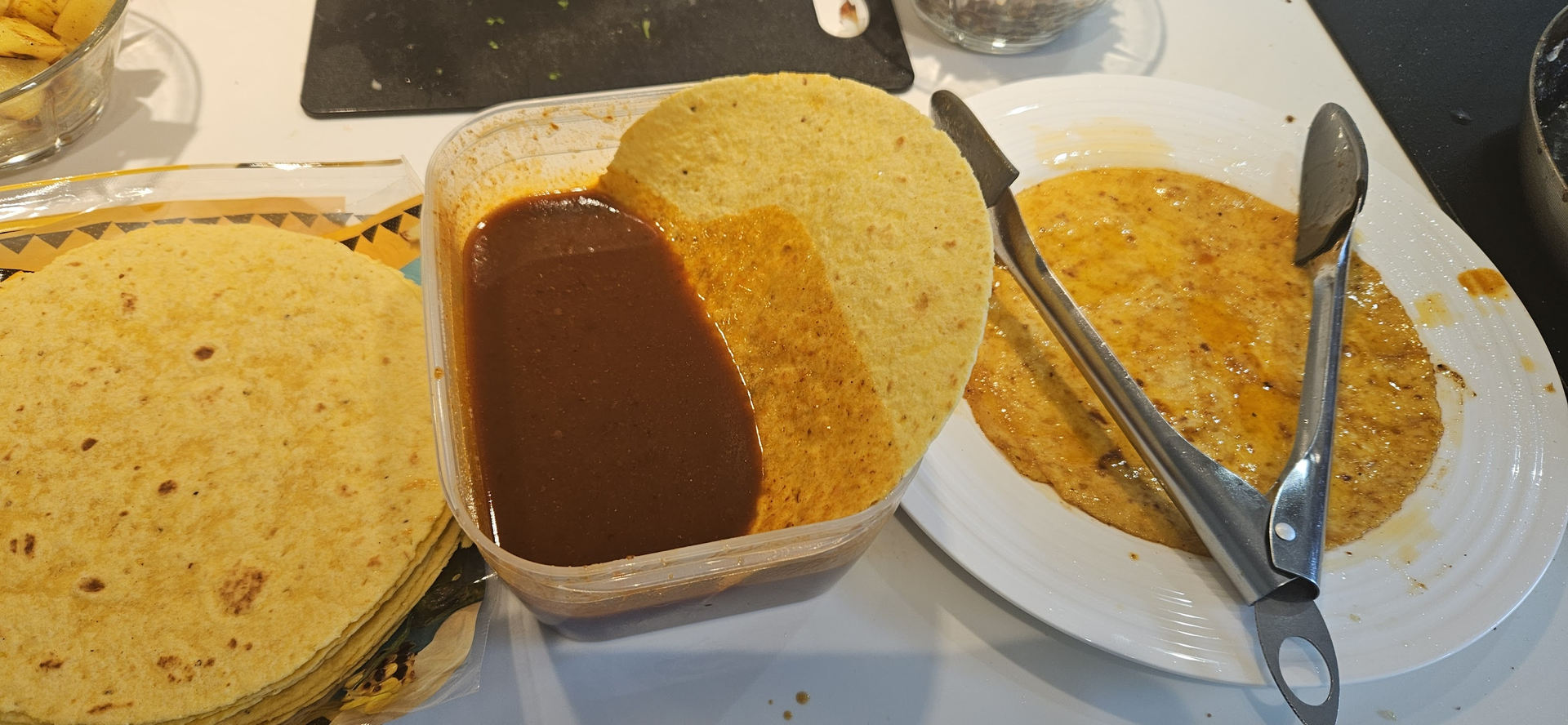Sausen tynnes med kraft, maistortillaene dyppes helt ned og stekes kort på begge sider så de fortsatt er myke.