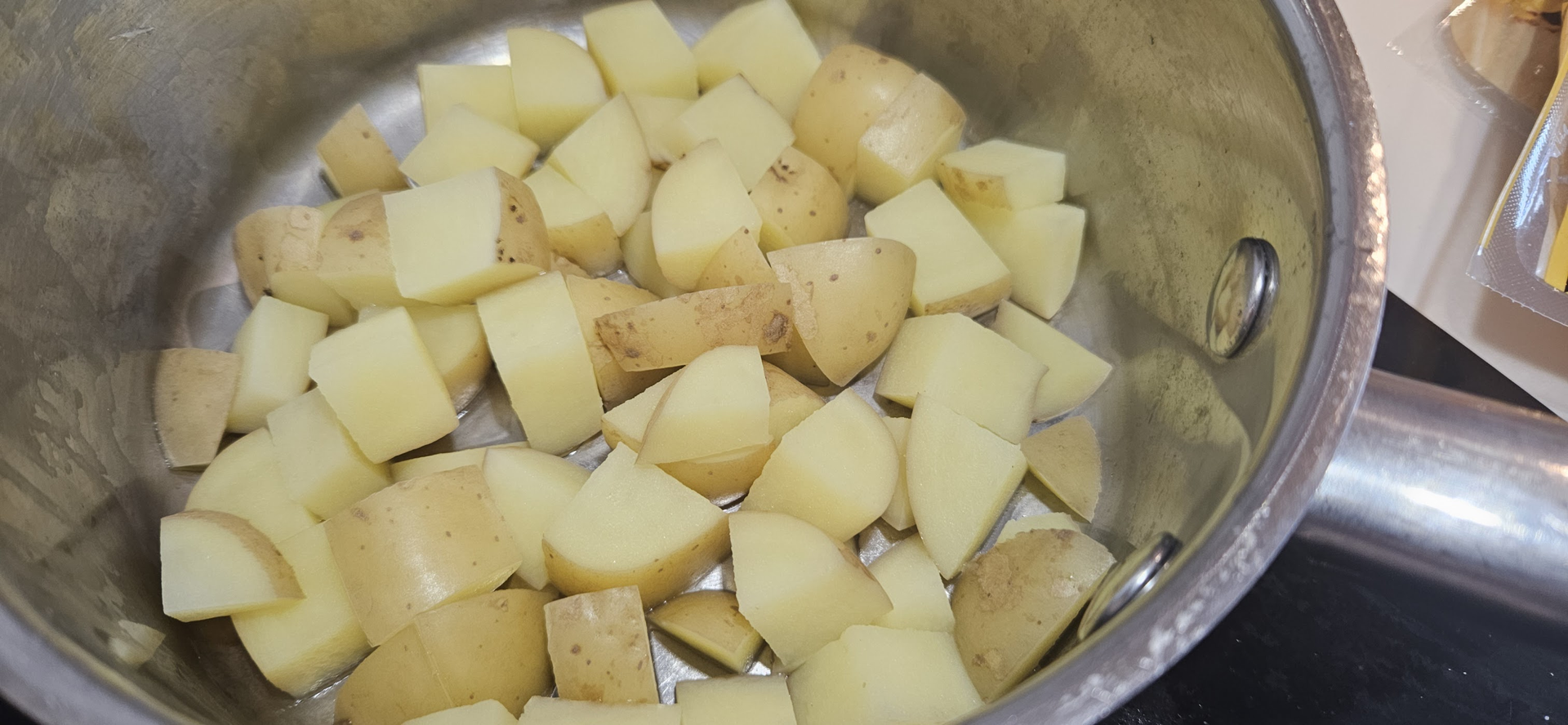 Potetene kuttes i ca. 1 cm terninger og kokes til de er møre, men fortsatt hele.