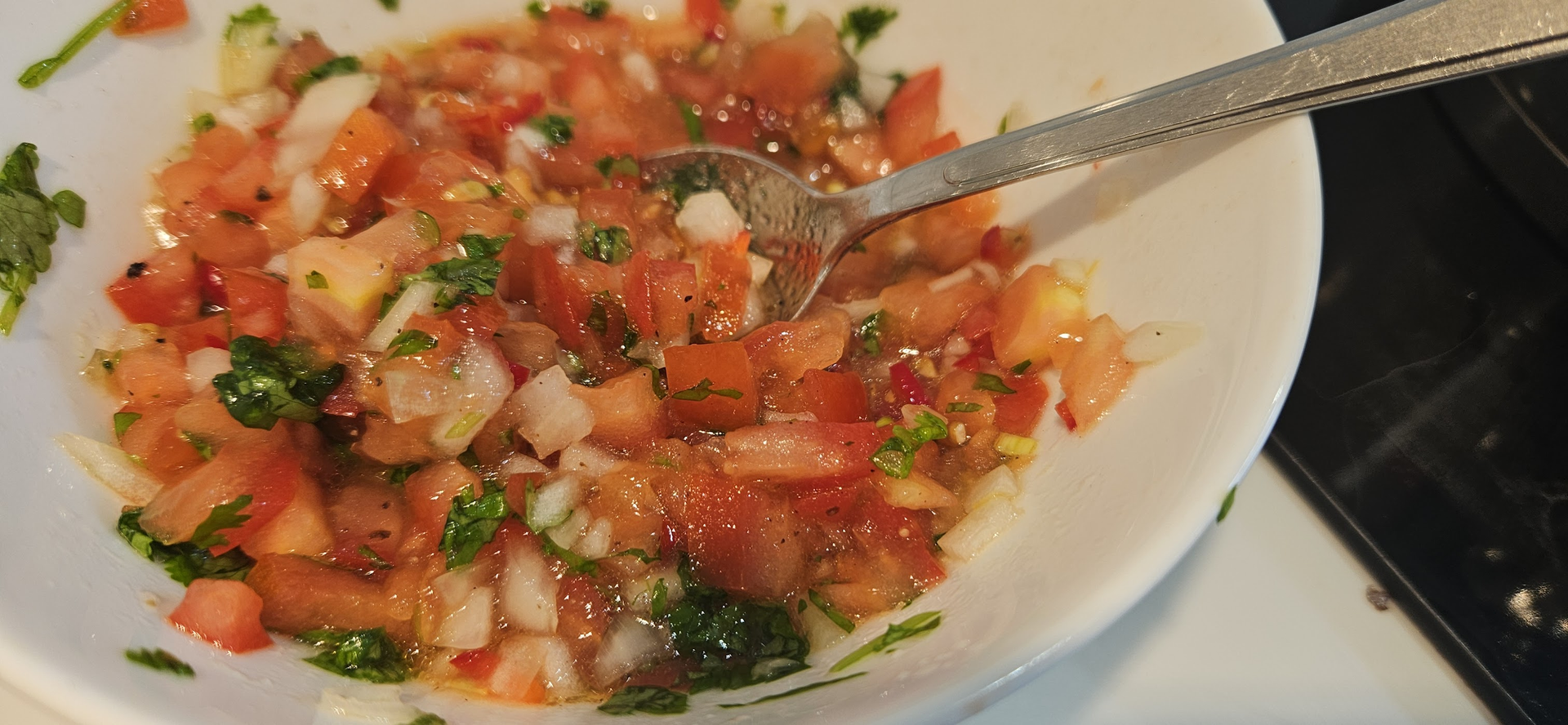 Rør sammen en rask salsa av løk, tomat, koriander, olivenolje, lime, salt, pepper og sukker.
