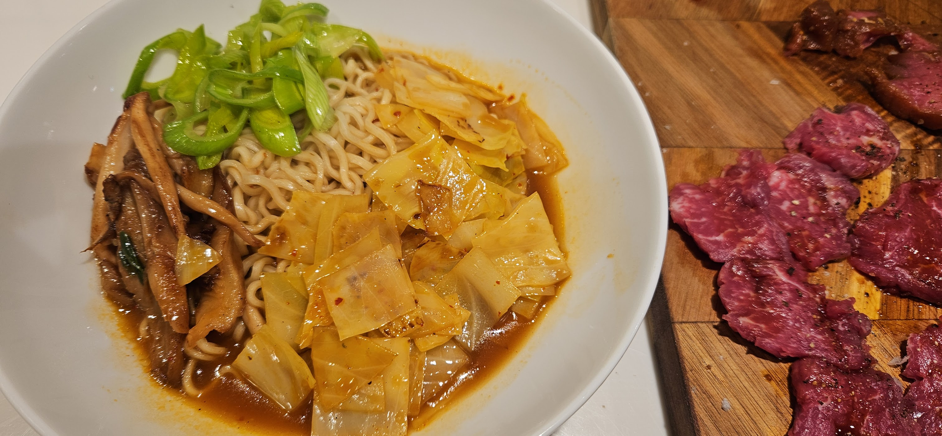 Cook the noodles and eggs, then sear the meat very briefly before building the bowls.